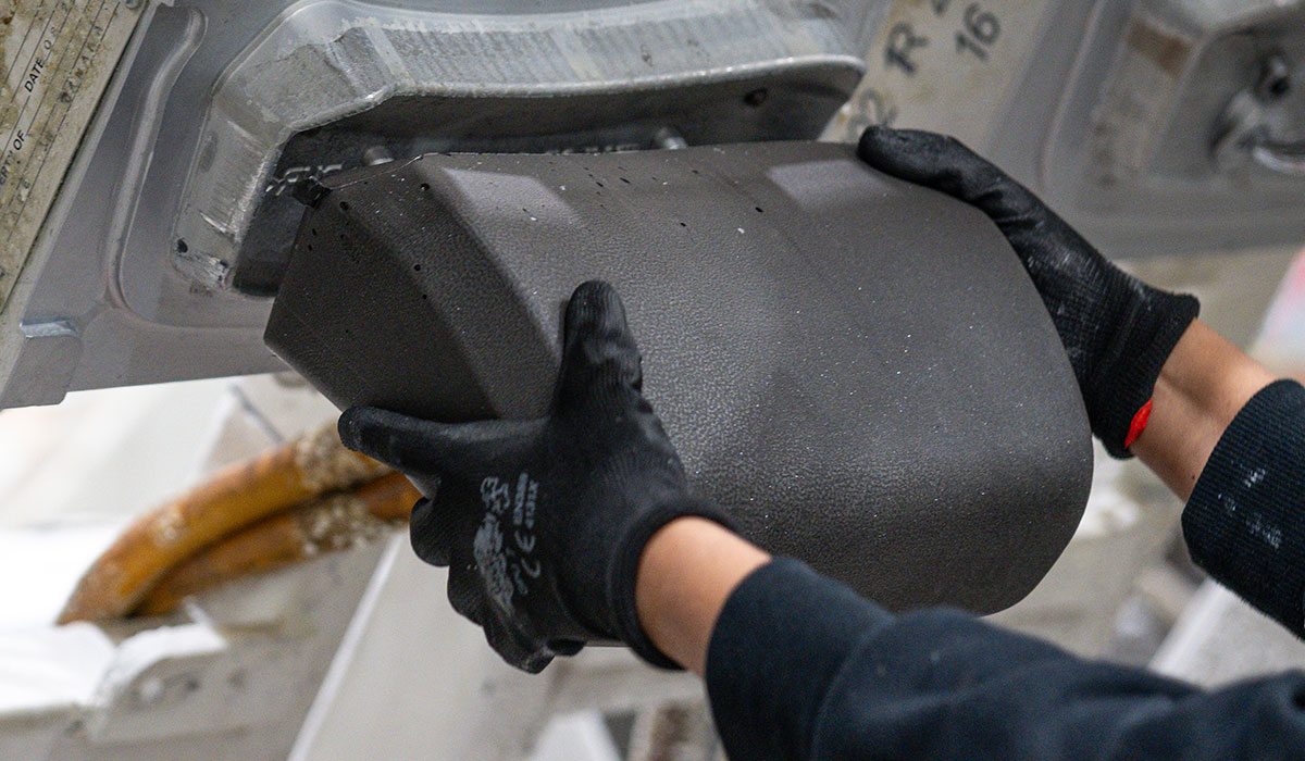 Employee with hands on headrest during foam